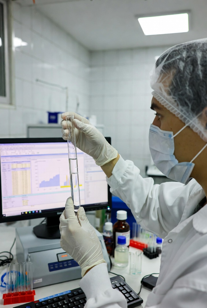 實驗室人員正在檢測樣品，電腦螢幕顯示檢驗數據報告